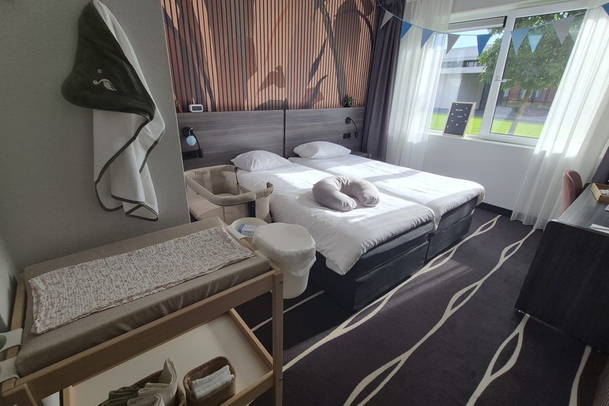 Hotelkamer van het kraamhotel met een opgemaakt tweepersoonsbed