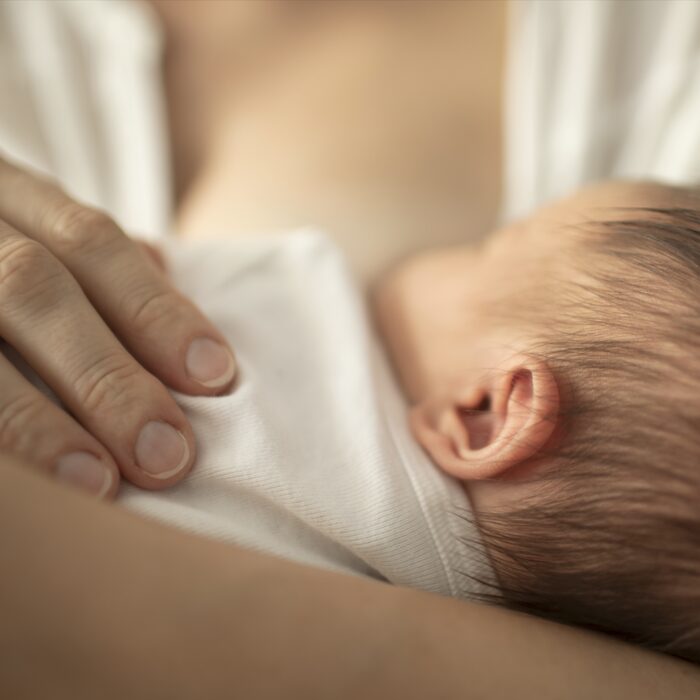 Moeder houdt haar pasgeboren baby dicht tegen zich aan
